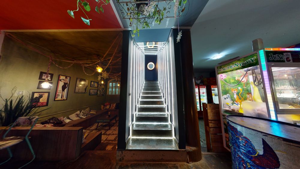 Escada iluminada em neon e balcão do Mocó Bar